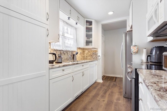 kitchen featuring stainless steel electric range, light stone countertops, and white cabinets