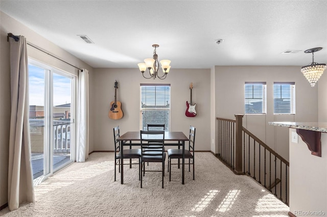 dining room featuring a wealth of natural light, light carpet, and a notable chandelier