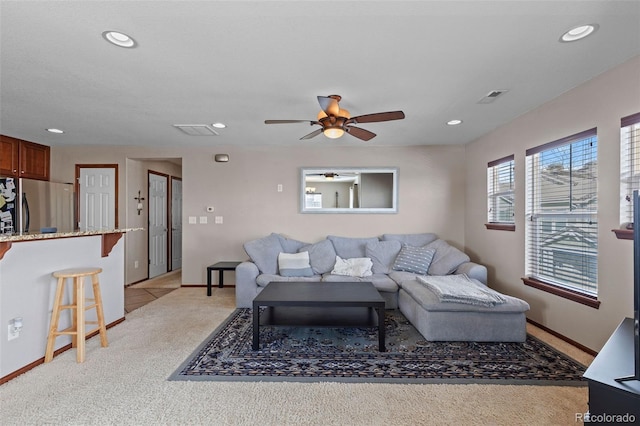 living area with recessed lighting, visible vents, and light carpet