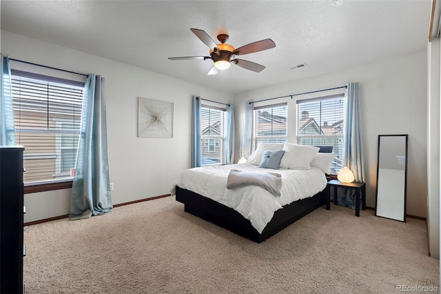 bedroom with baseboards, visible vents, a textured ceiling, and light colored carpet