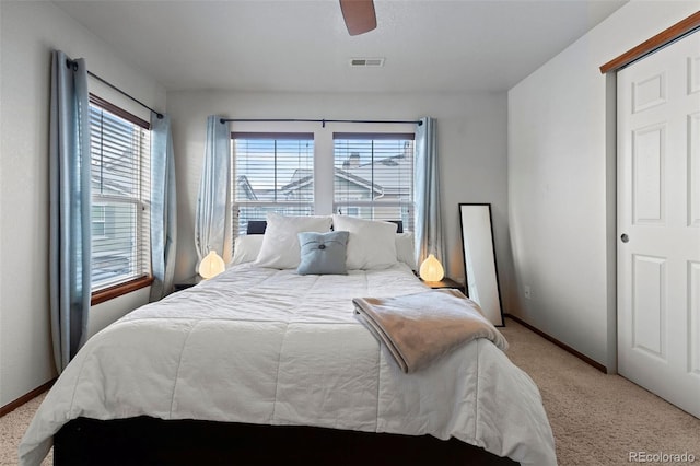 bedroom featuring light carpet, visible vents, a ceiling fan, and baseboards