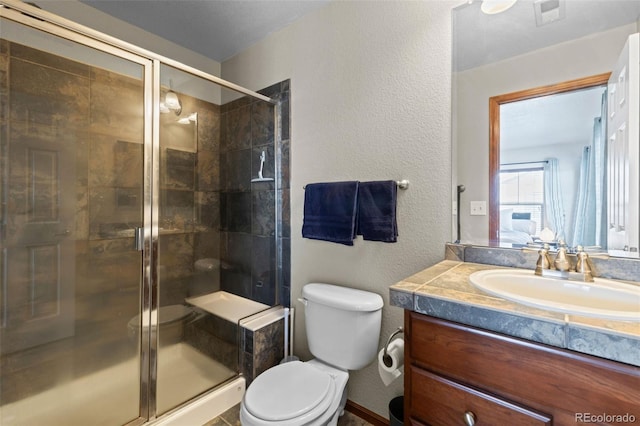 full bathroom with a textured wall, toilet, vanity, visible vents, and a shower stall