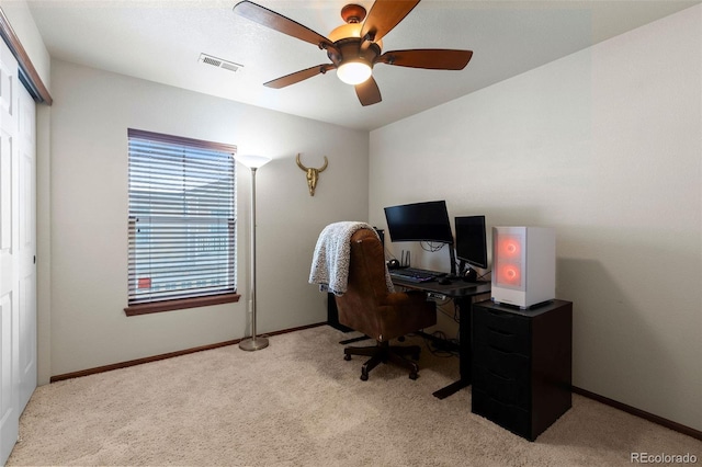 office space with light carpet, visible vents, baseboards, and a ceiling fan