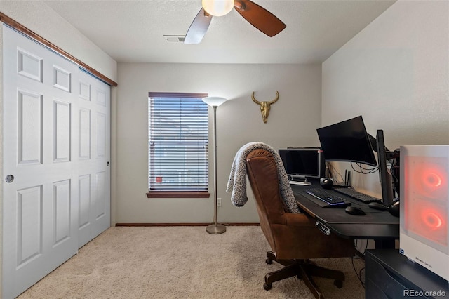 office space with visible vents, baseboards, a ceiling fan, light colored carpet, and a textured ceiling