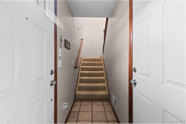 doorway with stairs, tile patterned flooring, and visible vents