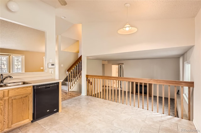 kitchen featuring lofted ceiling, black dishwasher, a textured ceiling, pendant lighting, and sink