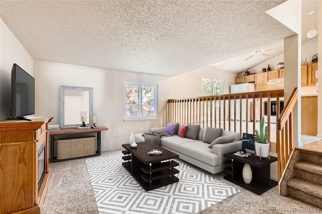 living room with vaulted ceiling, light carpet, and a textured ceiling