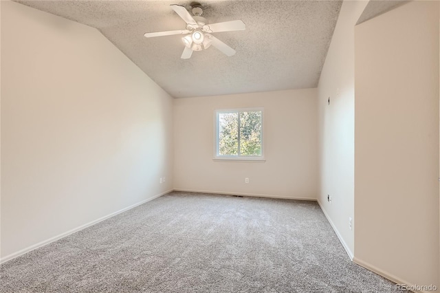 carpeted empty room with lofted ceiling, a textured ceiling, and ceiling fan