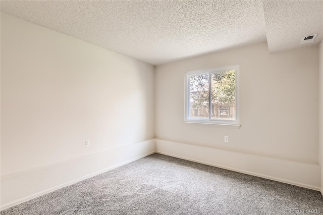 carpeted spare room with a textured ceiling