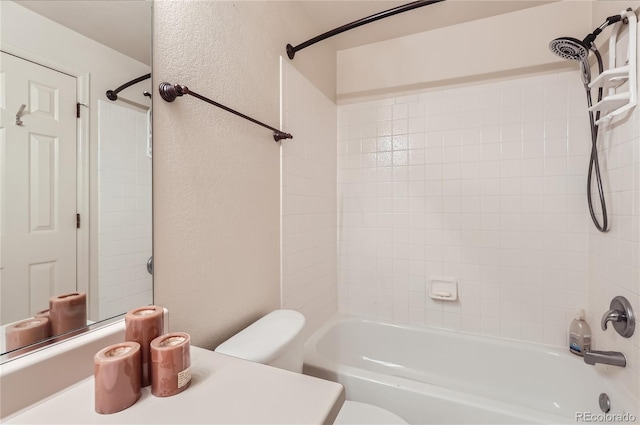 bathroom with tiled shower / bath combo and toilet