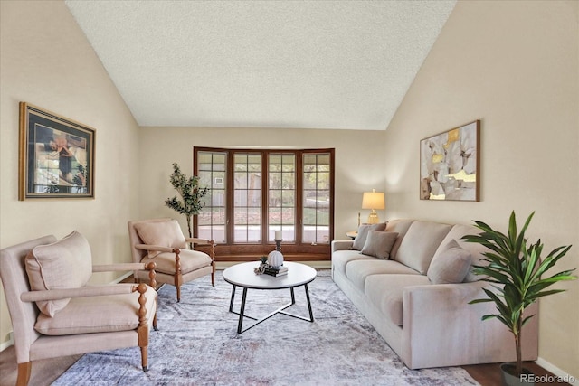 living area featuring lofted ceiling, a textured ceiling, and baseboards