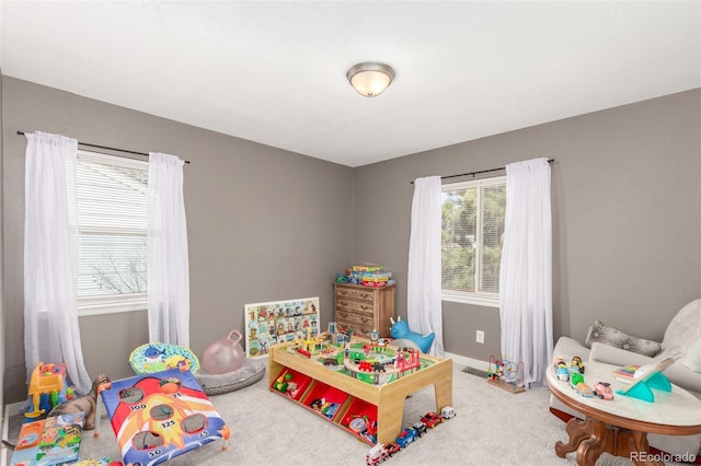 recreation room with baseboards and carpet flooring