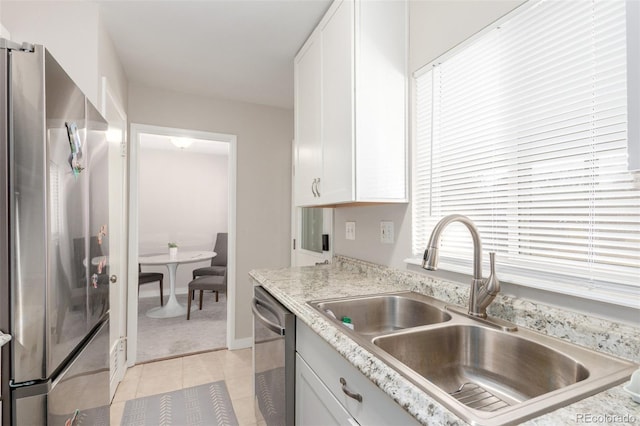 3041 S Glencoe St, Denver, CO 80222 - kitchen with appliances with stainless steel finishes, white cabinets, light tile patterned floors, and light stone counters