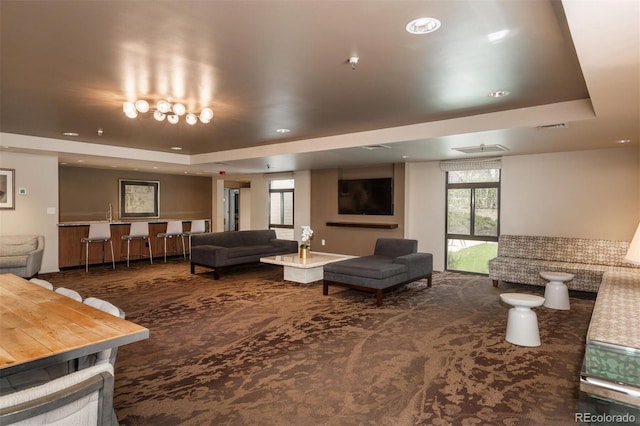 carpeted living room featuring a raised ceiling