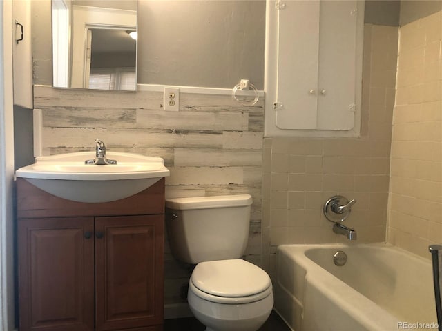 bathroom with vanity, tile walls, toilet, and wainscoting