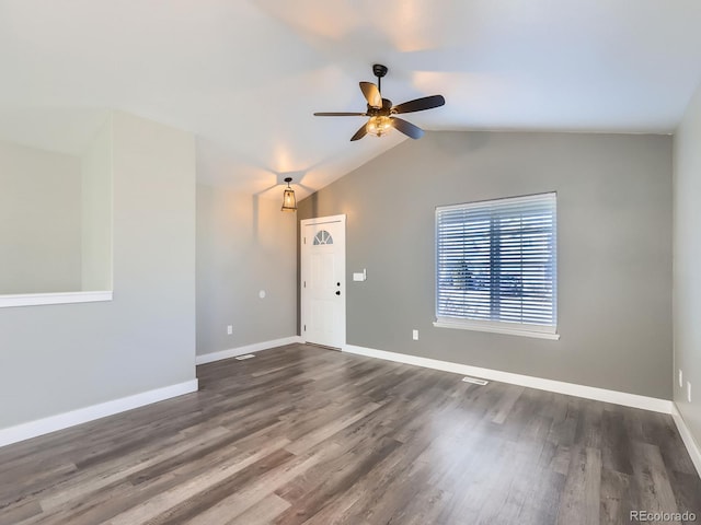 empty room with a ceiling fan, dark wood-style flooring, vaulted ceiling, and baseboards