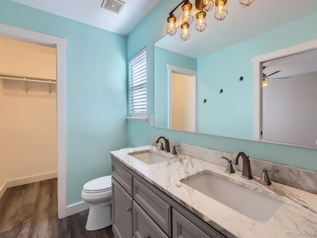 bathroom with toilet, visible vents, a sink, and wood finished floors