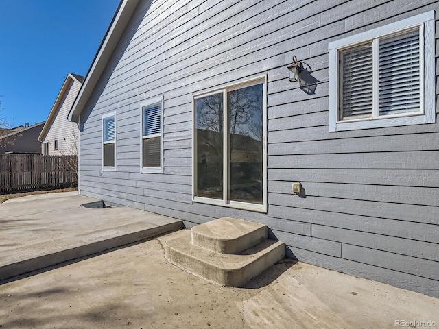 view of home's exterior with a patio area and fence