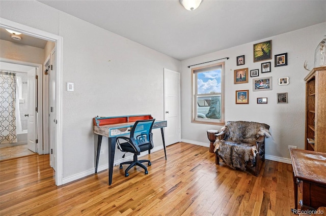 office space featuring baseboards and light wood-type flooring