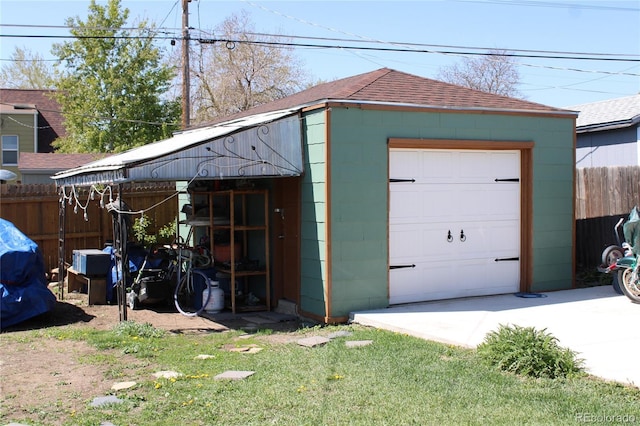 detached garage with fence and concrete driveway