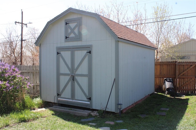 view of shed featuring fence