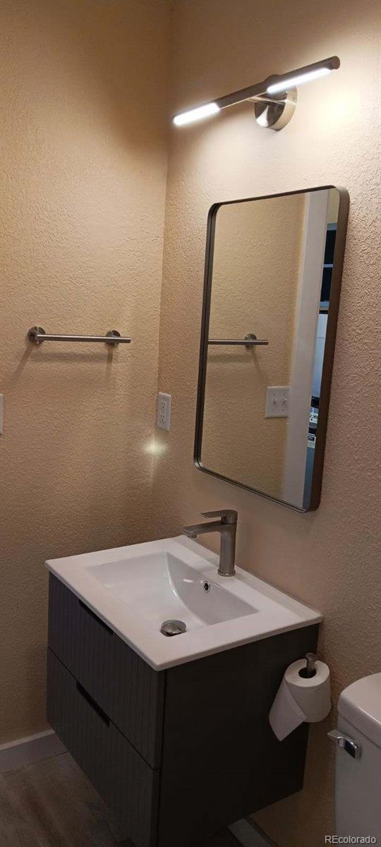 bathroom featuring vanity, wood-type flooring, and toilet