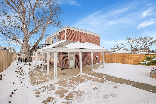 view of snow covered back of property