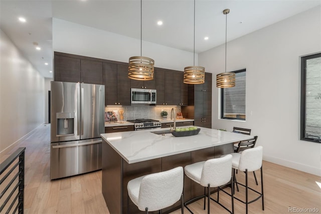 21 Washington Ave, Golden, CO 80403 - kitchen with stainless steel appliances, light wood finished floors, backsplash, dark brown cabinetry, and recessed lighting