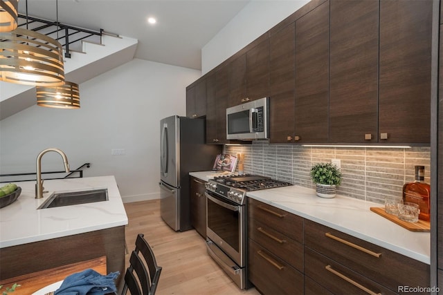21 Washington Ave, Golden, CO 80403 - kitchen with stainless steel appliances, decorative backsplash, light wood-type flooring, dark brown cabinetry, and recessed lighting