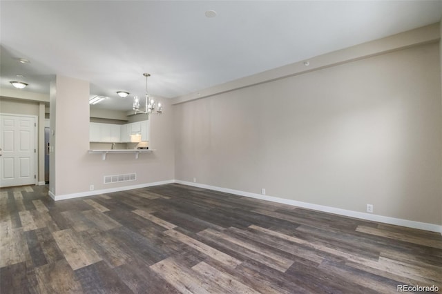 interior space featuring dark hardwood / wood-style flooring and an inviting chandelier