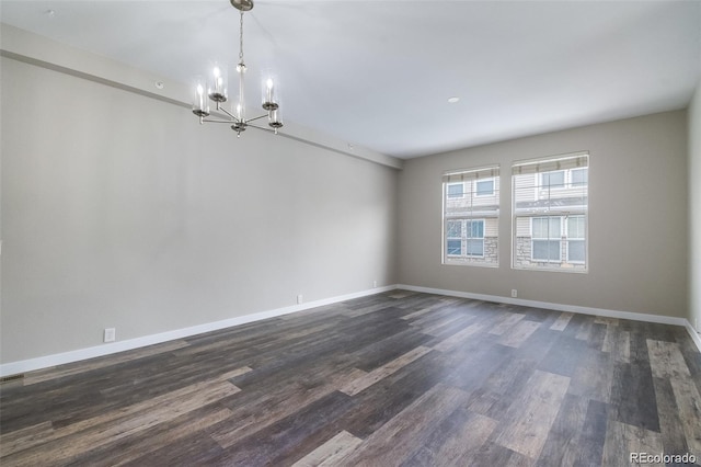 unfurnished room featuring a chandelier and dark hardwood / wood-style flooring