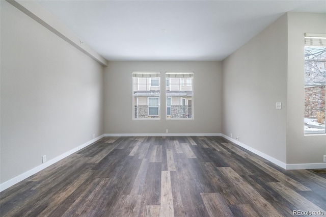 unfurnished room featuring plenty of natural light and dark hardwood / wood-style flooring