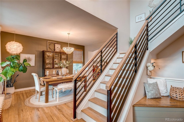 8229 Cottongrass Ct, Castle Pines, CO 80108 - stairs with wood finished floors and a chandelier