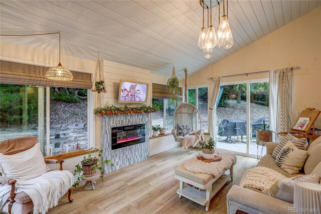 8229 Cottongrass Ct, Castle Pines, CO 80108 - living room with vaulted ceiling, wood finished floors, a glass covered fireplace, a chandelier, and wooden ceiling