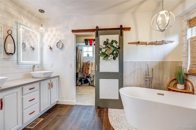 8229 Cottongrass Ct, Castle Pines, CO 80108 - bathroom featuring a freestanding tub, wood finished floors, and double vanity