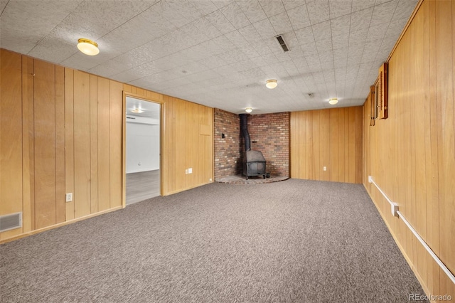 1026 Spencer St, Longmont, CO 80501 - finished below grade area with a wood stove, carpet, and wooden walls