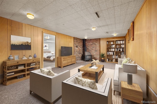 1026 Spencer St, Longmont, CO 80501 - carpeted living room featuring a wood stove, wood walls, and built in shelves