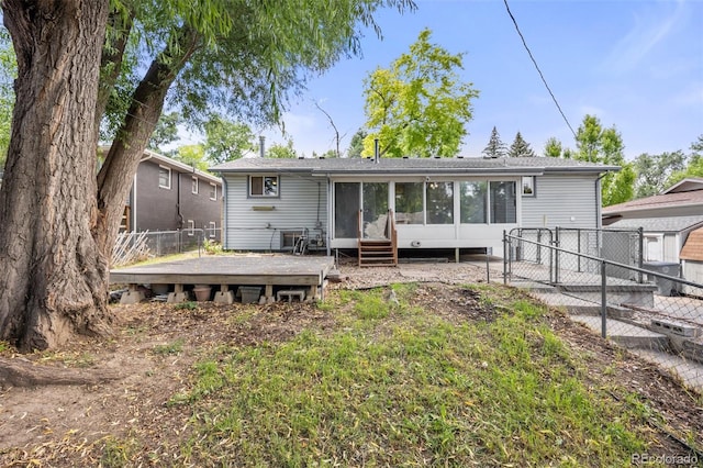 1026 Spencer St, Longmont, CO 80501 - rear view of property with a fenced backyard, a wooden deck, a sunroom, and a gate