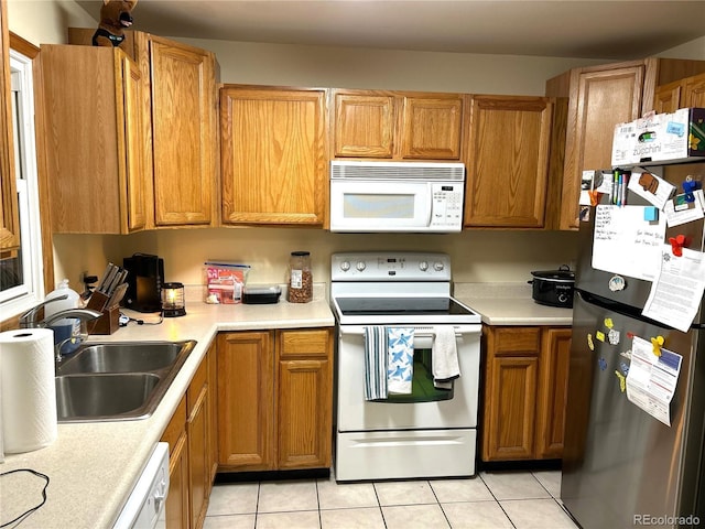 kitchen with white appliances, sink, and light tile patterned floors