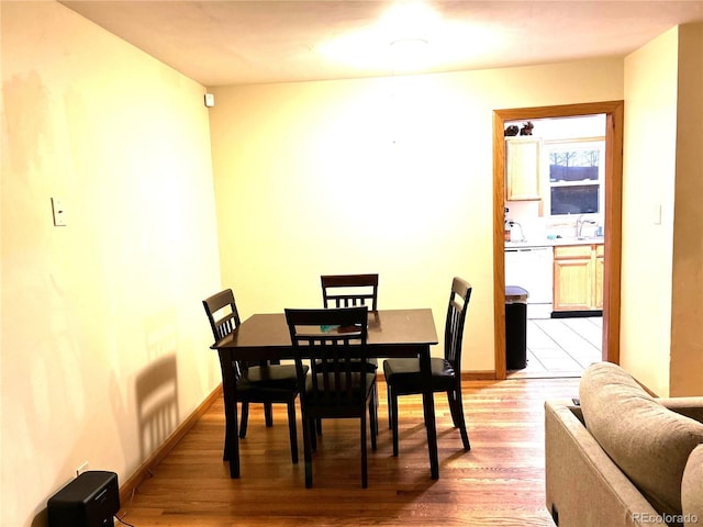 dining area with sink and light wood-type flooring