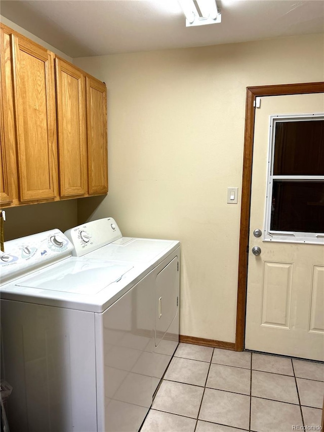 laundry room featuring cabinets, washing machine and dryer, and light tile patterned flooring