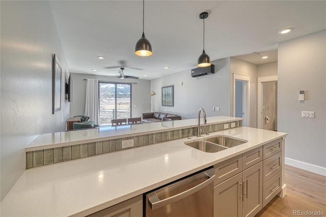 kitchen with a sink, open floor plan, dishwasher, and light countertops