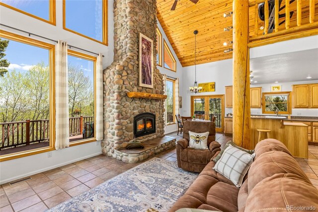 180 Ridge Rd, Cimarron, CO 81220 - living room with high vaulted ceiling, light tile patterned floors, baseboards, a stone fireplace, and wood ceiling