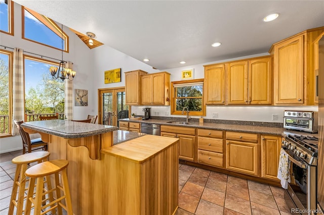 180 Ridge Rd, Cimarron, CO 81220 - kitchen with a sink, stainless steel appliances, a breakfast bar, high vaulted ceiling, and a chandelier