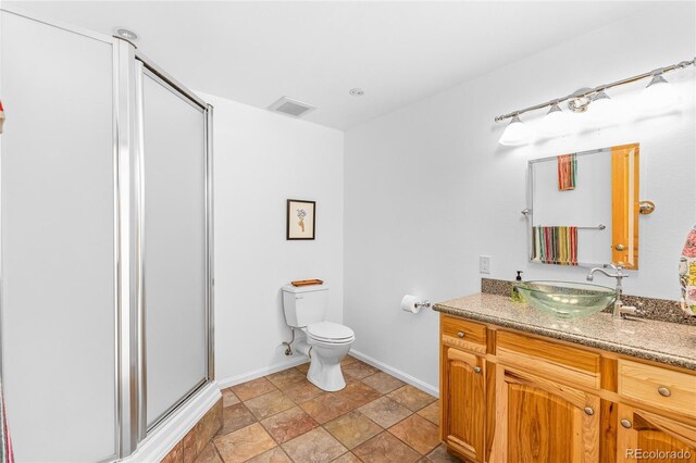 180 Ridge Rd, Cimarron, CO 81220 - bathroom with vanity, a stall shower, toilet, baseboards, and stone finish floors