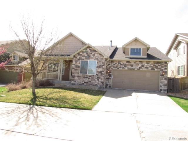 view of front of property featuring fence, a front lawn, concrete driveway, an attached garage, and stone siding