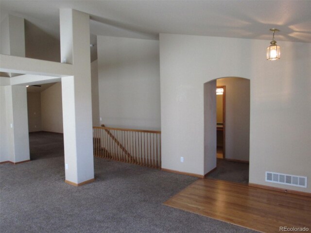 unfurnished room with arched walkways, baseboards, carpet flooring, and visible vents