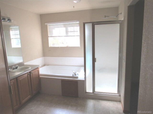 full bath with vanity, a garden tub, a stall shower, and tile patterned floors
