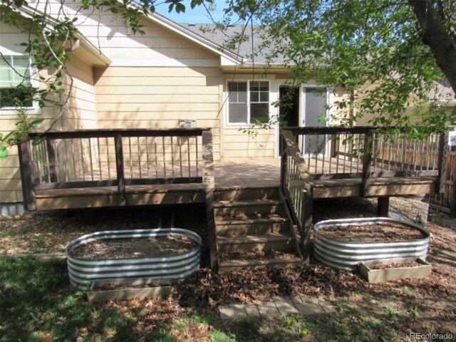 rear view of house featuring a wooden deck and stairs
