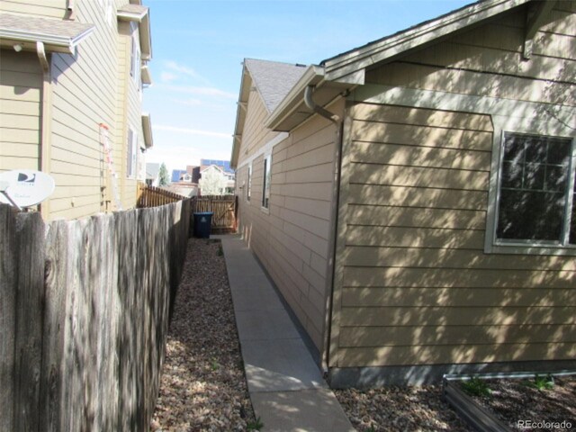 view of side of home featuring fence